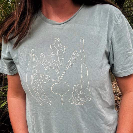 Person wearing a light blue t-shirt with white plant design outdoors